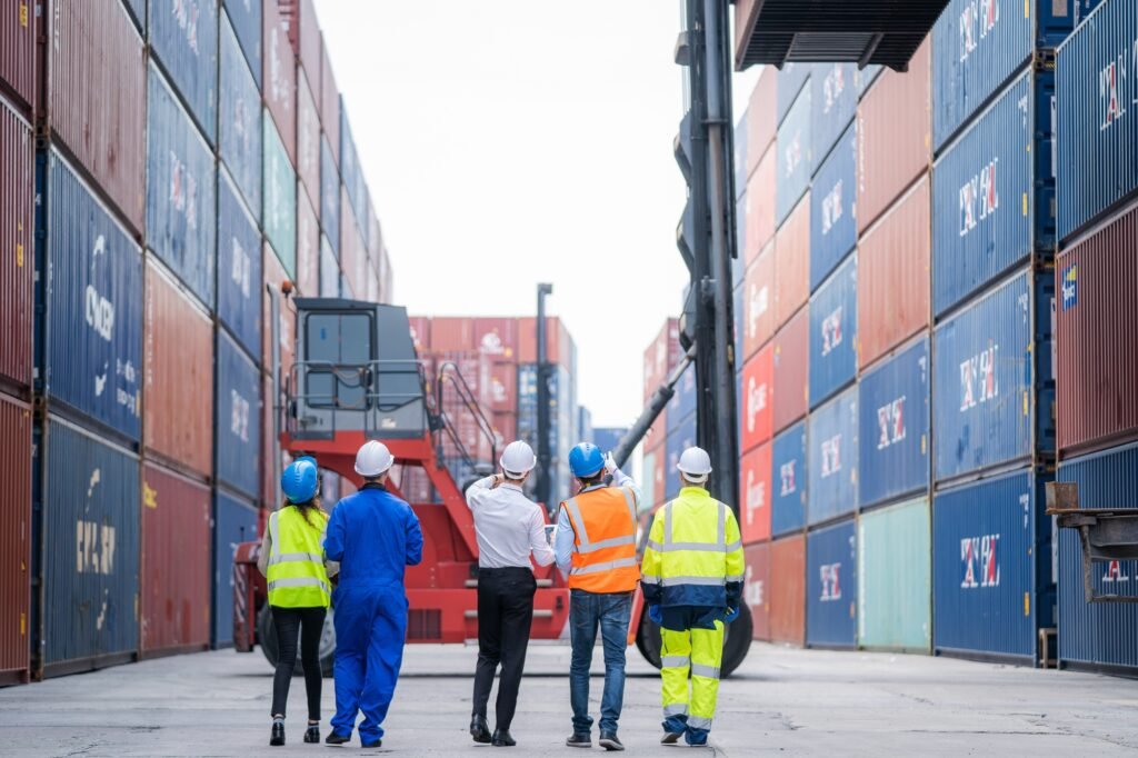 Manager and professional container yard workers checking stock for loading in the container yard.